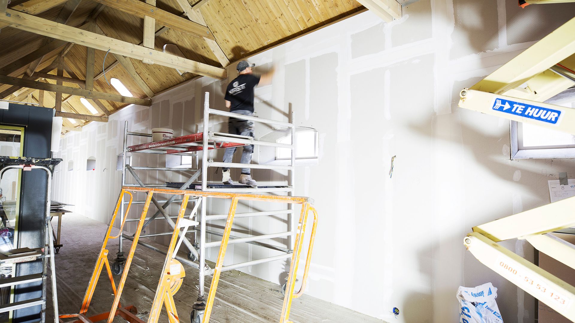 Vakman aan het werk op steiger